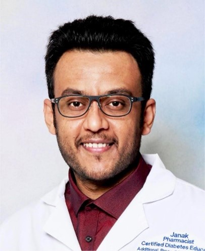 Janak Patel, Treasurer and Board Director of Alberta Independent Pharmacy Association, wearing a white pharmacist coat.