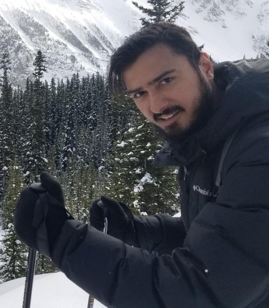 Mohsin Muhammad, Board Director at Alberta Independent Pharmacy Association, outdoors in winter gear with snowy forest background.